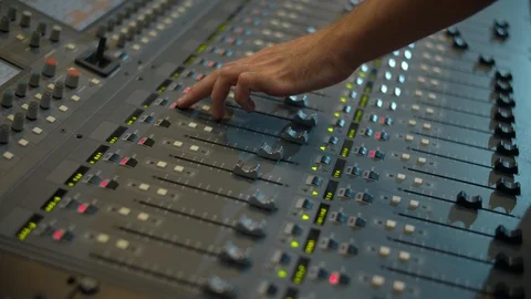 Close-up of a mixing console, the hand adjusts the faders. Sound director works Video stock 116040394