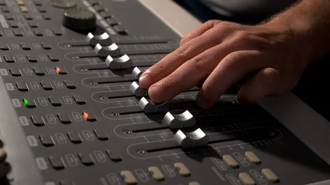 Close-up of a mixing console, the hand adjusts the faders. Sound director works Video stock 125632922