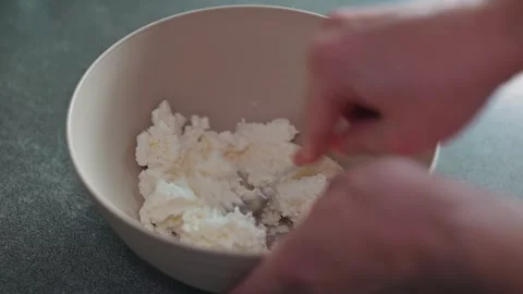 Close-up of mixing ingredients in a bowl with a fork, stirring the cottage Stock Footage 339096260