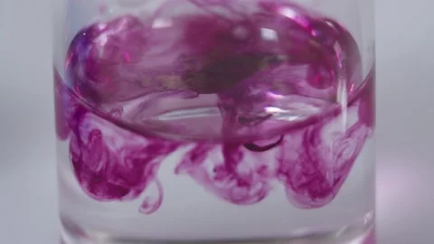 Close-up of mixing magenta colored substance with transparent liquid in a flask Stock Footage 201344760