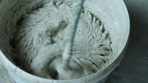 Close-up of mixing plaster in a bucket with an electric hand mixer Stock Footage 165141375