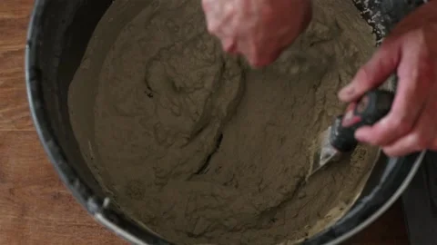 Close up of mixing plaster putty inside bucket with paddle mixer Stock Footage 339298314