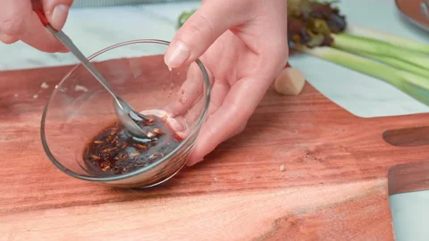 Close-up mixing a Seared tuna Sauce made of soya sauce, garlic, and oil in 4K. Stock Footage 141308671