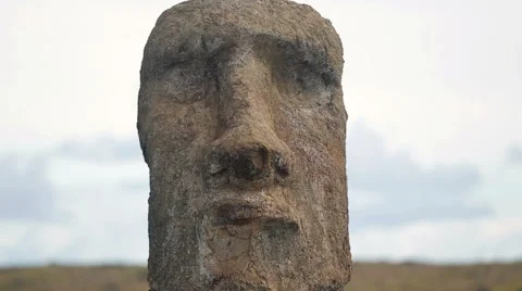 Close-up on Moai statue's face under the cloudy sky Stock Footage 64258187