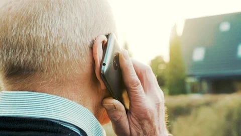 Close up of mobile phone being held next to ear during call with senior man Stock Footage 104607009