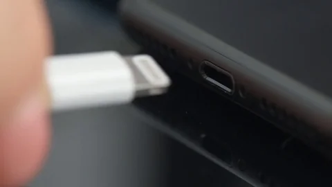 Close up of a mobile phone connected to a charger. Stockbeeldmateriaal 80593547