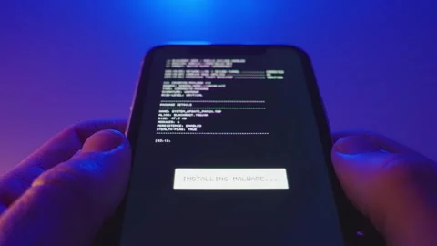 Close up on mobile phone with digital malware or virus app being installed 動画素材 323842381