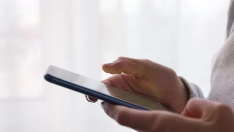 Close-up of a mobile phone in hands. Using a smartphone on social networks. Stock Footage 164375458