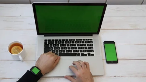 Close up Mockup of Man working on Laptop, Smartphone, Watch with Green Screen. Stock Footage 116613914