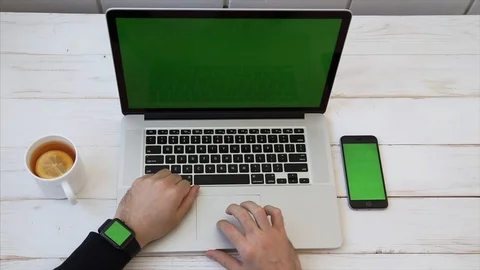 Close up Mockup of Man working on Laptop, Smartphone, Watch with Green Screen. Stock Footage 116613916