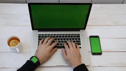 Close up Mockup of Man working on Laptop, Smartphone, Watch with Green Screen. Stock Footage 116613934