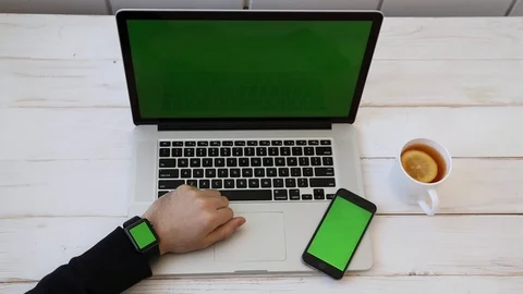 Close up Mockup of Man working on Laptop, Smartphone, Watch with Green Screen. Stock Footage 116613941