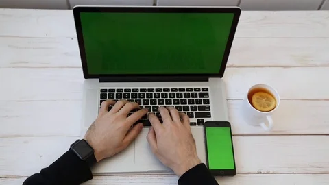 Close up Mockup of Man working on Laptop, Smartphone, Watch with Green Screen. Stock Footage 116613959