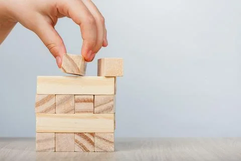 Close-up mockup of wooden rectangular cubes in hand. A hand puts rectangular Stock Photos