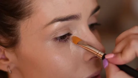 Close-up of a model being made up by a make-up artist in the dark circles are Stock Footage 134561665