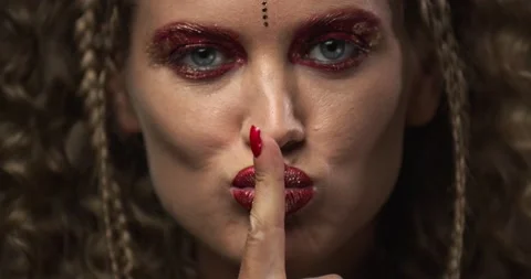Close up of a model doing shush gesture, bright red makeup and nail polish, 4k Stock Footage 143961087