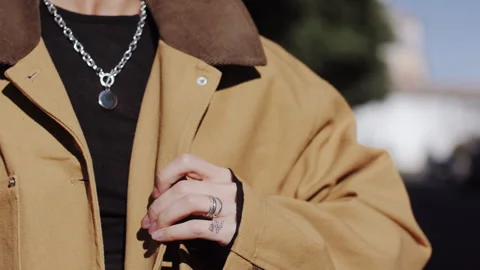 Close Up of Model Hand with Rings Fastening Stylish Jacket 库存影片 337503910