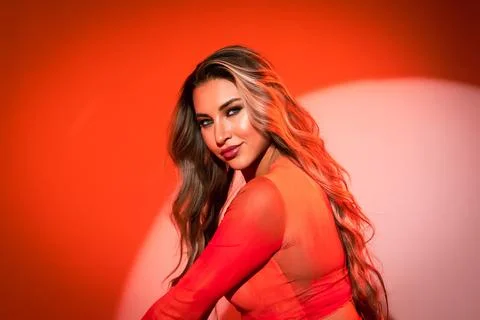 Close-up of a model on an orange background in a blouse with an expressive and Фото