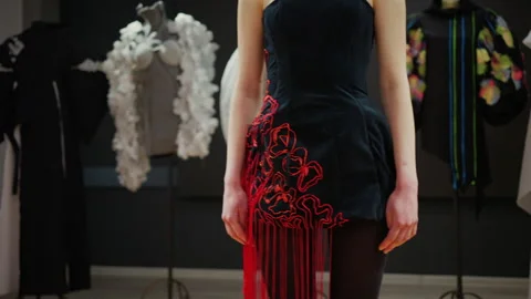 Close up of a model wearing a black outfit with red thread elements extending Stock Footage 335351753