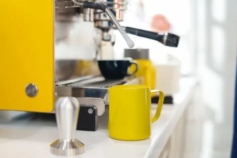 Close up of modern coffee machine and yellow pincher on bar counter. Stock Photos