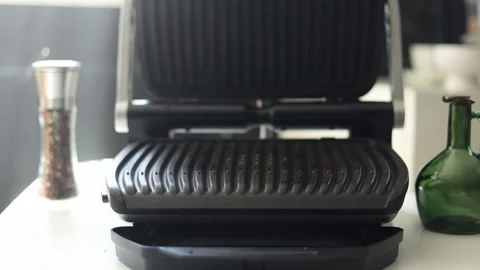 Close-up of a modern electric grill with pepper and oil on a kitchen counter Vidéo 342280639