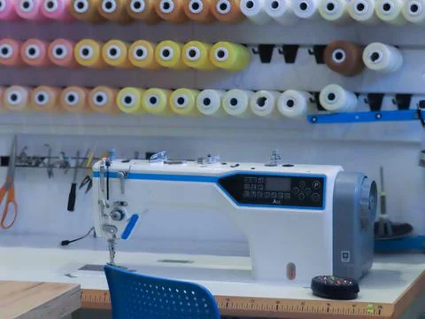 Close-up of a modern electronic sewing machine with colorful thread spools Stock Photos