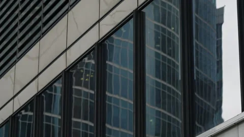 Close-up of a modern glass facade with vertical mullions reflecting a curving Stock Footage 327531113