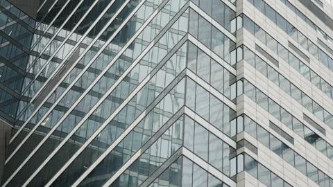 Close-up of a modern glass skyscraper facade with geometric zigzag lines Video stock 327531132