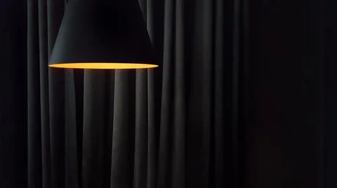 Close-up on a modern lamp against the background of the folds of curtains in Stock Photos