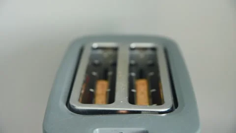 Close up of modern metallic toaster slots with bread pieces inside blurred .. Stock Footage 334570339