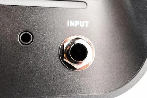 Close-up of a modern mini guitar amp speaker, featuring a metal input jack .. 写真素材