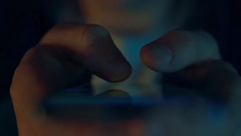Close-up of a modern smartphone user's hands. Fingers scroll through the pag Stock Footage 256936993