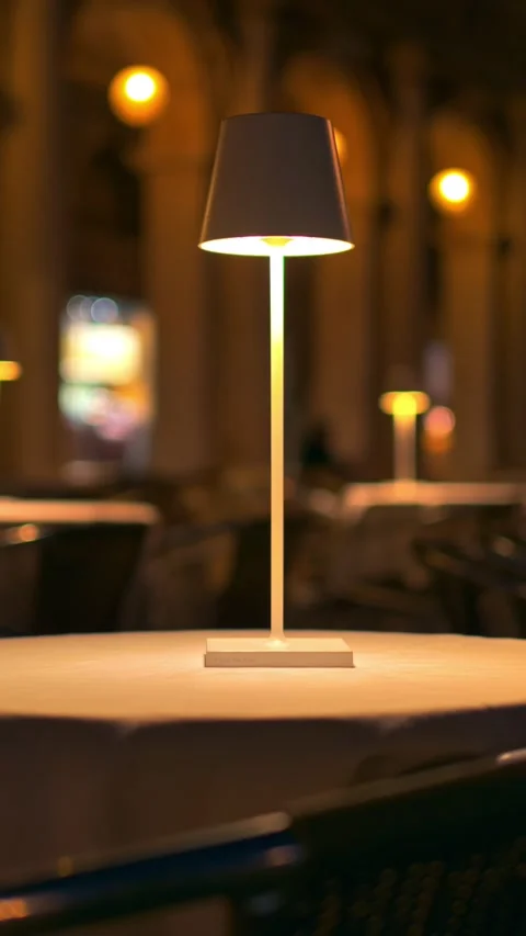 Close up on modern table lamp on restaurant table at night illuminated by w.. Stock Footage 339641263