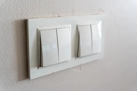 Close-up of modern wall light switch installed in home interior, demonstrating Stock Photos