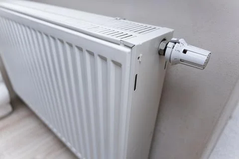Close-up of a modern white radiator installed in an indoor setting. The image Stock Photos
