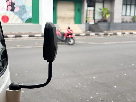 Close-up of a Modern White Van Side Mirror on a City Street Background Stock Photos