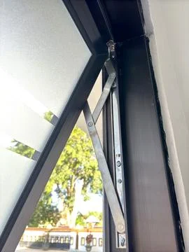 Close-up of a modern window hinge system with metal brackets and frosted glass Stock Photos
