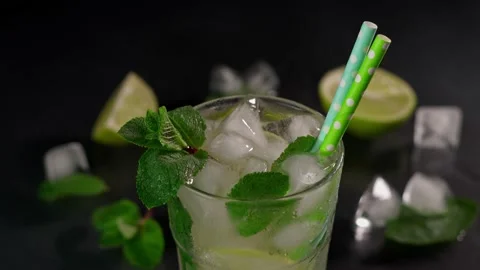 Close-up of Mojito Cocktail with lime, ice cubes and green mint leaves Stock Footage 237436426