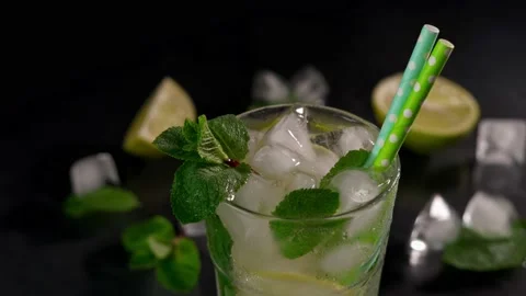 Close-up of Mojito Cocktail with lime, ice cubes and green mint leaves Stock Footage 237436451