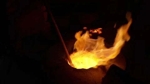 Close up of molten metal bubbling in a glowing crucible with bright orange Video stock 332376329