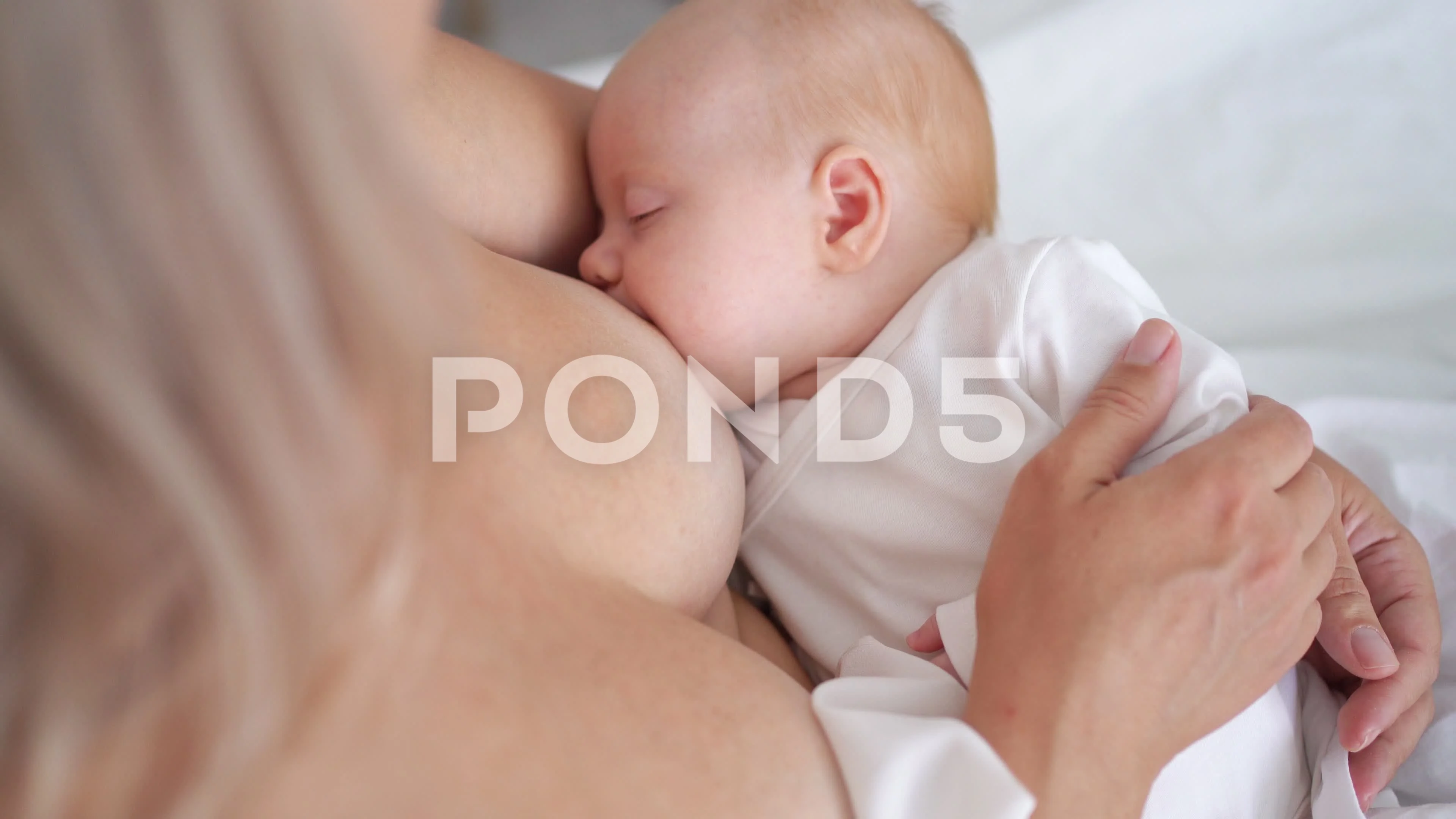 Foto de Breastfeeding baby close up. Pretty mother holding her