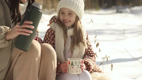 Close up. Mom pours warm tea to her daughter from a thermos Stock Footage 154205815