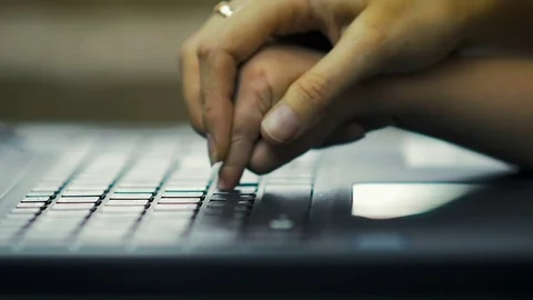 Close-up a mom teaches her three-year-old daughter to print text on the laptop Video stock 82396572