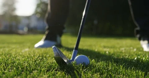 Close up of a moment when ball being strongly hitted by a club on the green golf Stock Footage 82367194