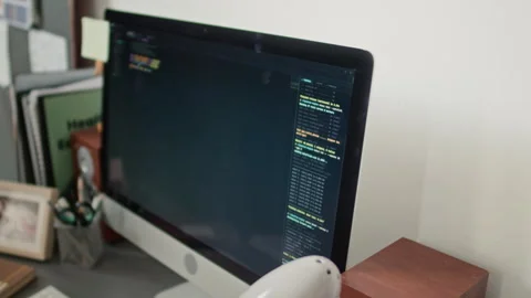 Close up of Monitor Displaying Code, Surrounded by Office Supplies Stock Footage 333212748