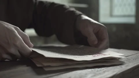 Close up of monk hands putting a parchment page on a stack of manuscripts Stock Footage 337929828