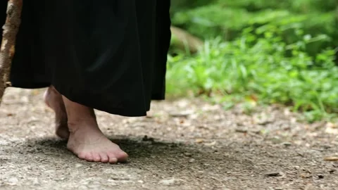 Close up of a monk's steps on a forest road emphasizes a simple lifestyle. Stock Footage 336785874