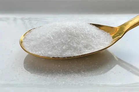Close up of monosodium glutamate, MSG on a spoon on white background. Stock Photos