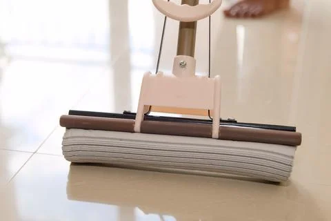Close Up Of Mop Cleaning Shiny Tile Floor In Home Stock Photos