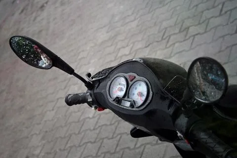 Close-up moped control panel in the rain Black Speedometer with raindrops 写真素材
